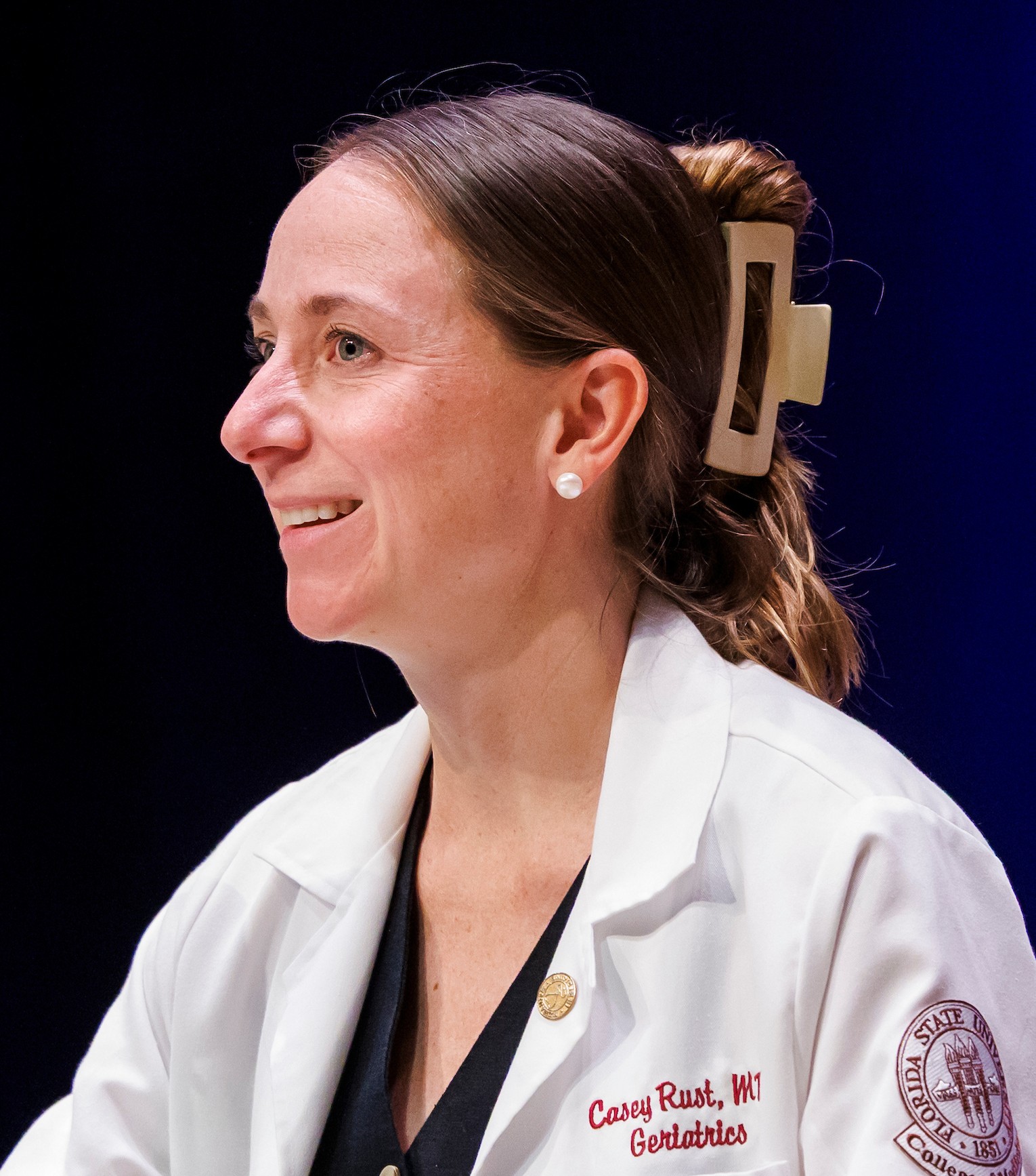 Head shot of Dr. Casey Rust at podium.