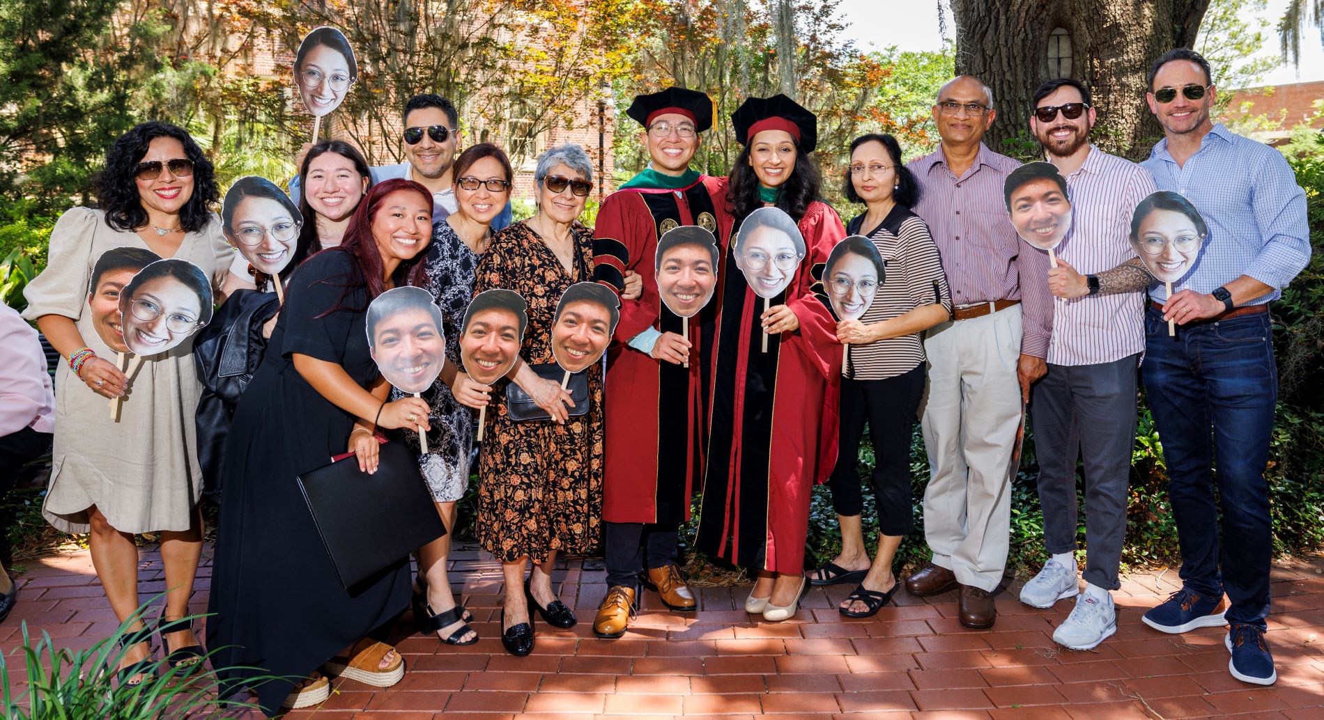 Dr. Ishani Patel and Dr. Daniel Alban, surrounded by their families and holding masks.