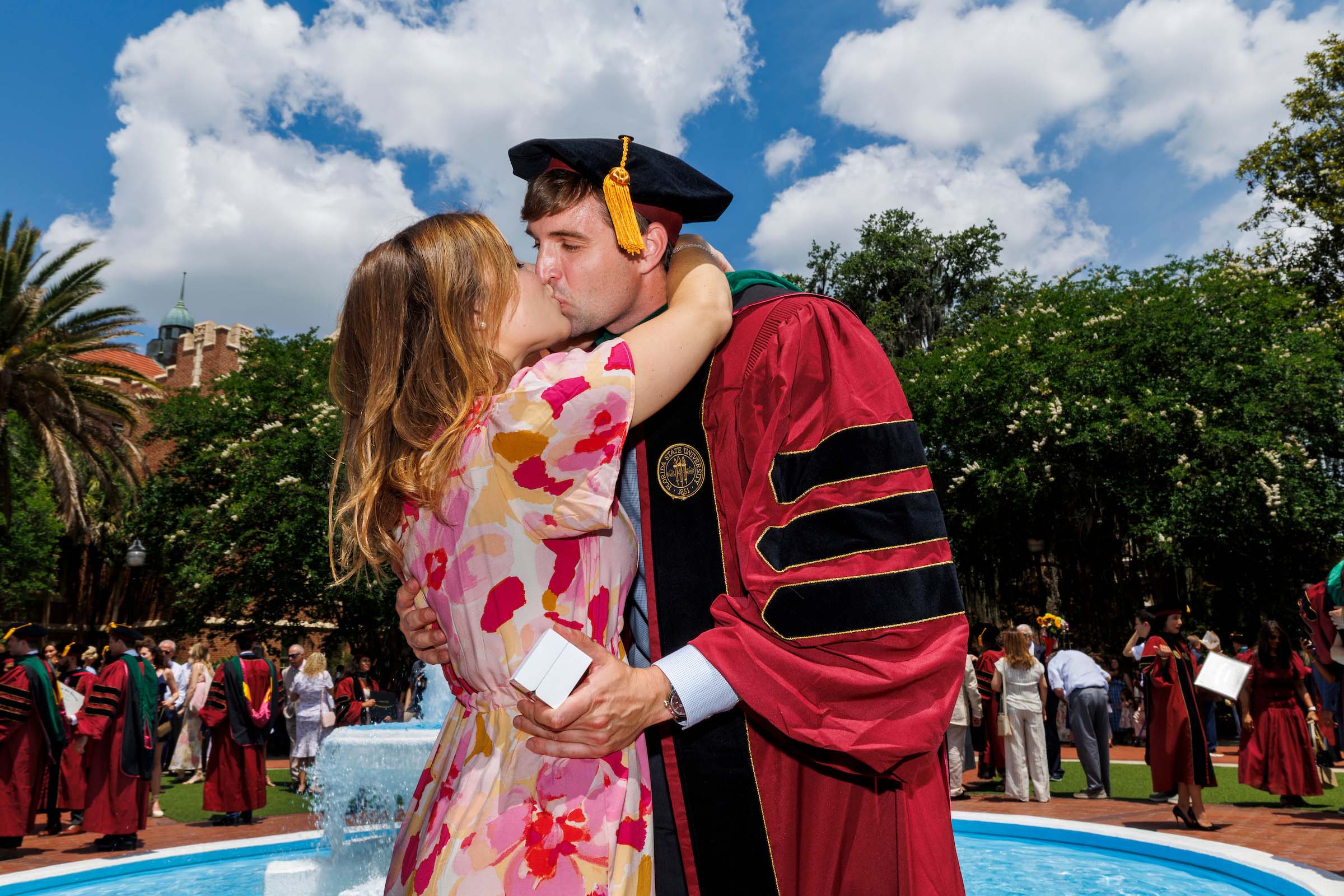 Maxx Harrell (M.D. '26) plants a kiss on Lexi Michas to celebrate their commencement day engagement. (Photo by Colin Hackley)