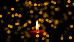 An image of a candle flame surrounded by other pops of light.