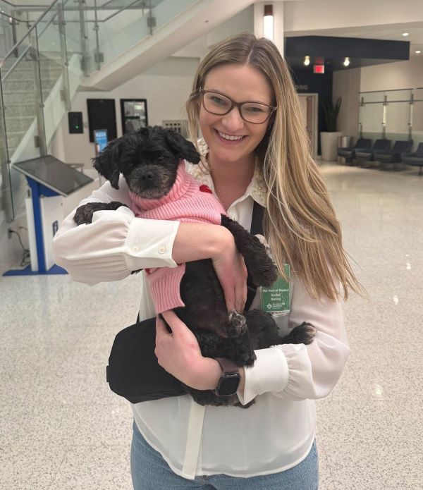 Student, Rachel Bielling, holding a small dog.