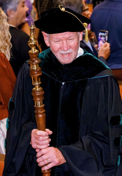 Dr. Paul McLeod carries the mace.