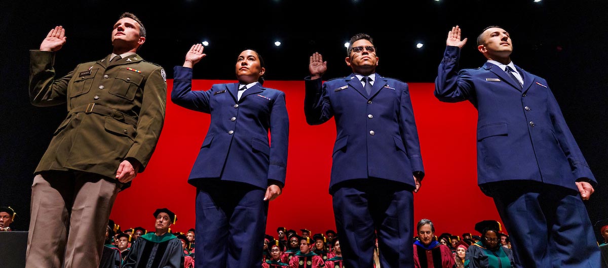 Military graduates from left to right: Ryan Peacock, Erika Balazs, Mike Ilerena and Nathan Steineck repeat the oath after receiving their orders.