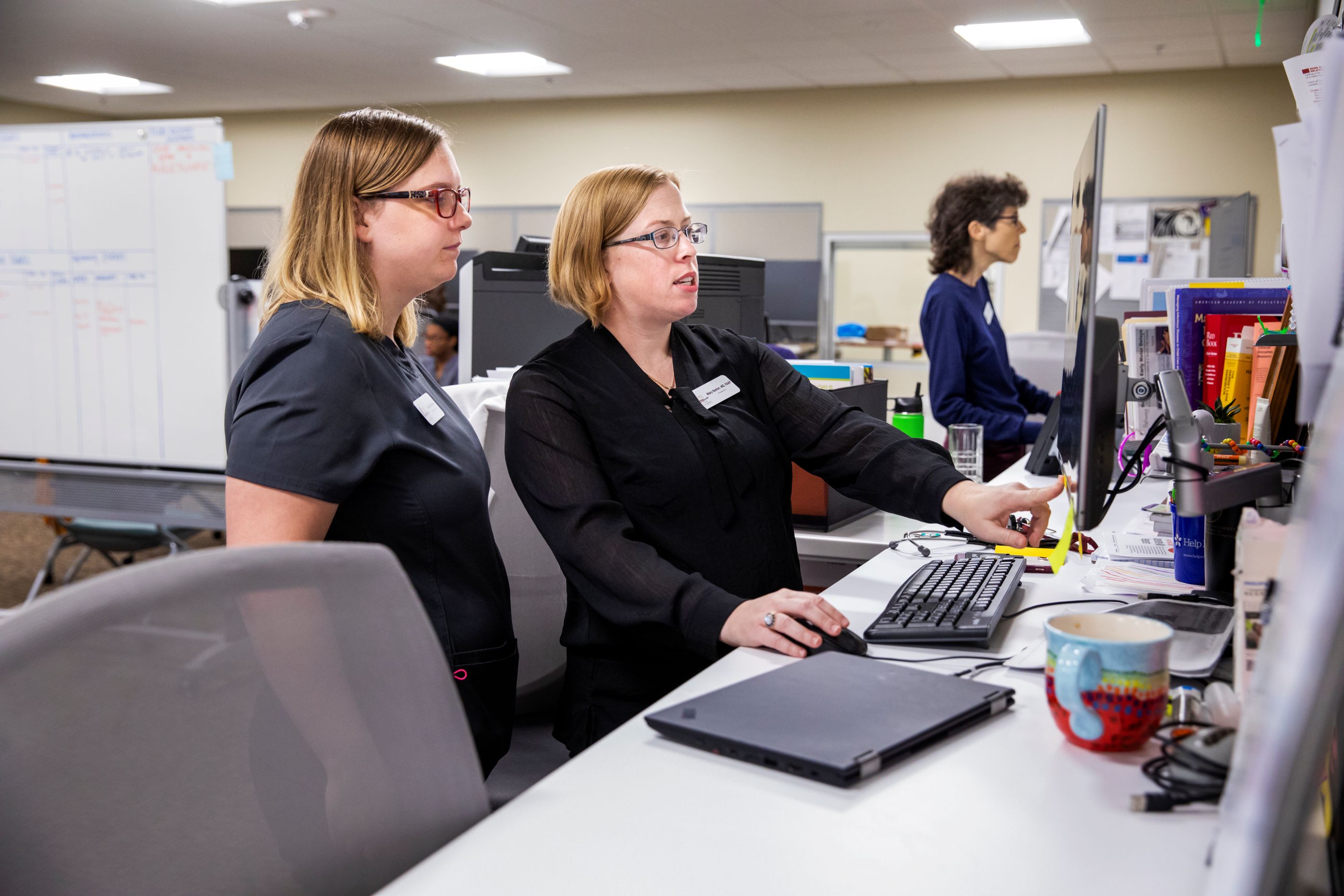 Doctors work with a medical student at the work station known as "The Island."