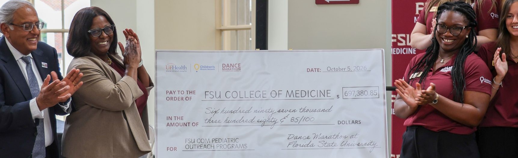 Dr. Rashmin Savini, Dr. Alma Littles and Emmannuella Essien reveal the check.