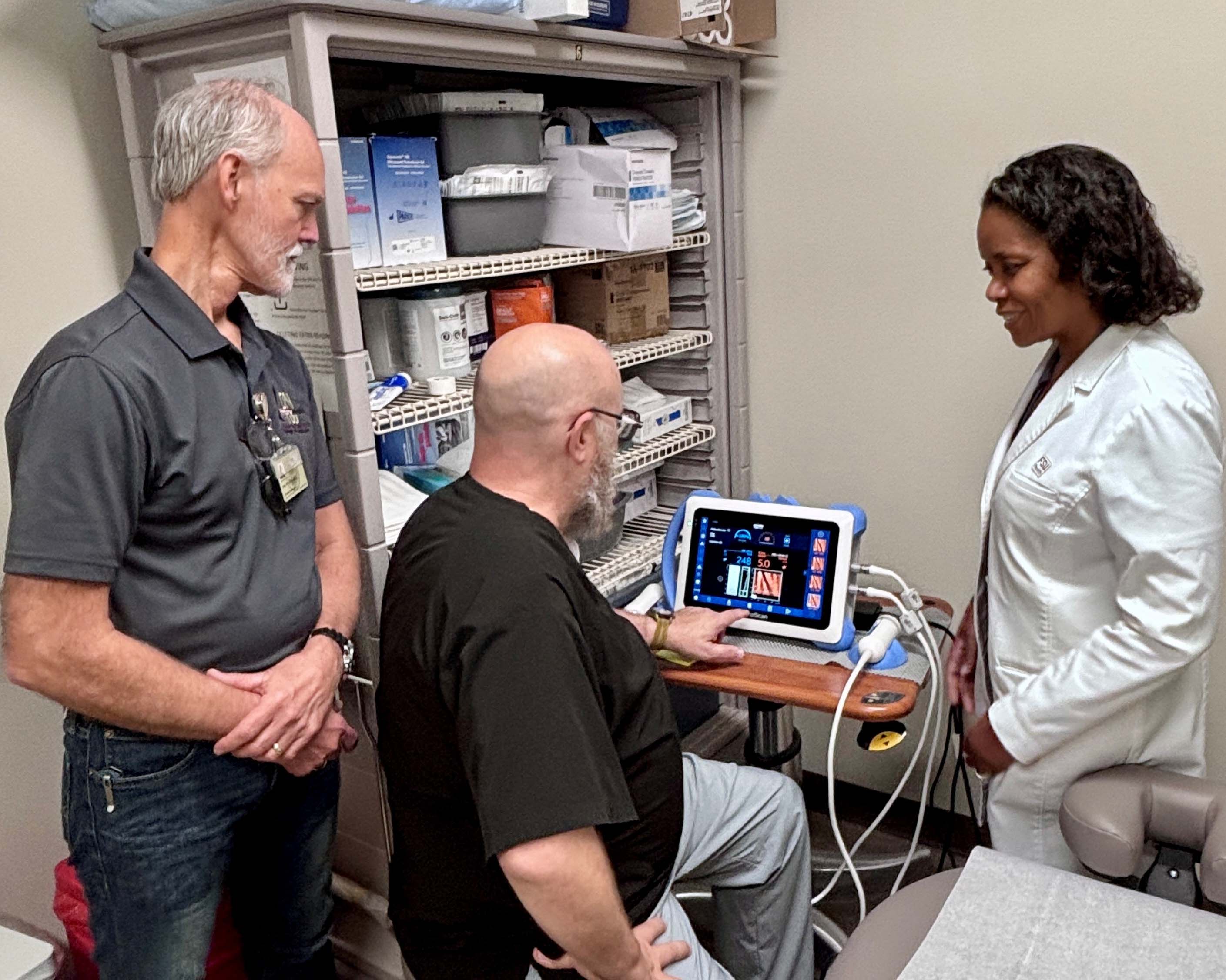 Three people around the liver scanner.