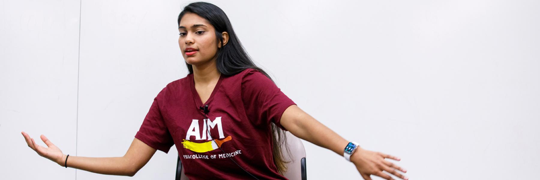Aanchal Shah, a second-year M.D. student and president of the College of Medicine's AIM program, demonstrates dance movement.
