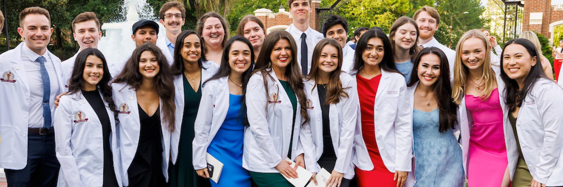 A group of recently "coated" medical students gathers near Westcott fountain for a celebratory photo.