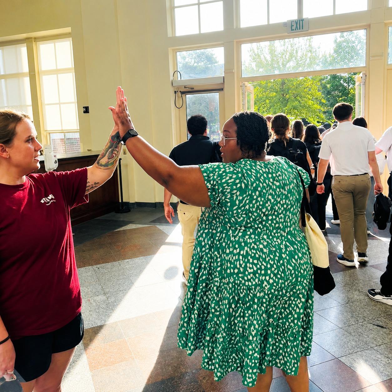 Katie Odom and Dr. Flowers high fiving in FSU COM Lobby