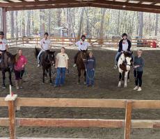 Students posing on horse back with Hands and Hearts for Horses staff.