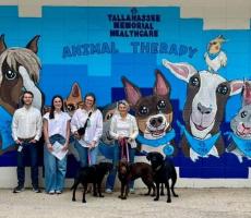 Students posing with TMH Animal Therapy staff and dogs.