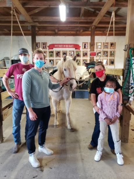 Third year medical students Tim Carter (left) and Ben Borgert (center left) volunteer with Hands and Hearts for Horses as part of their Community Medicine rotation. 