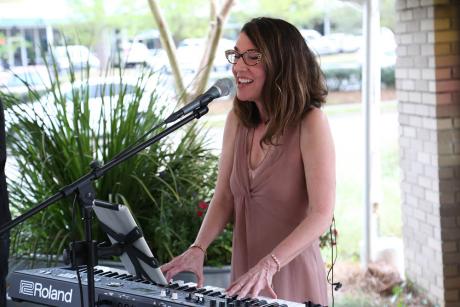 Cathy Levenson, PhD playing the keyboards and singing at our 2019 Wine Tasting Gala.