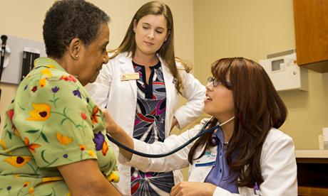 Alumna and student with patient