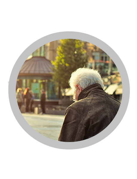 Picture of a man sitting on a bench. Gray circle around the picture.