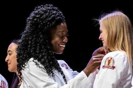 Efe Cudjoe pins Ally Davis during their Gold Humanism Honor Society induction ceremony in August 2019; photo by Colin Hackley