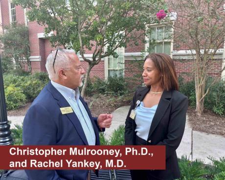 Christopher Mulrooney, Ph.D., and Rachel Yankey talk in the Wellness Garden.