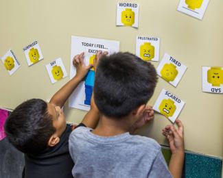 Two boys share how they're feeling as part of Adverse Childhood Experience (ACE) screening.